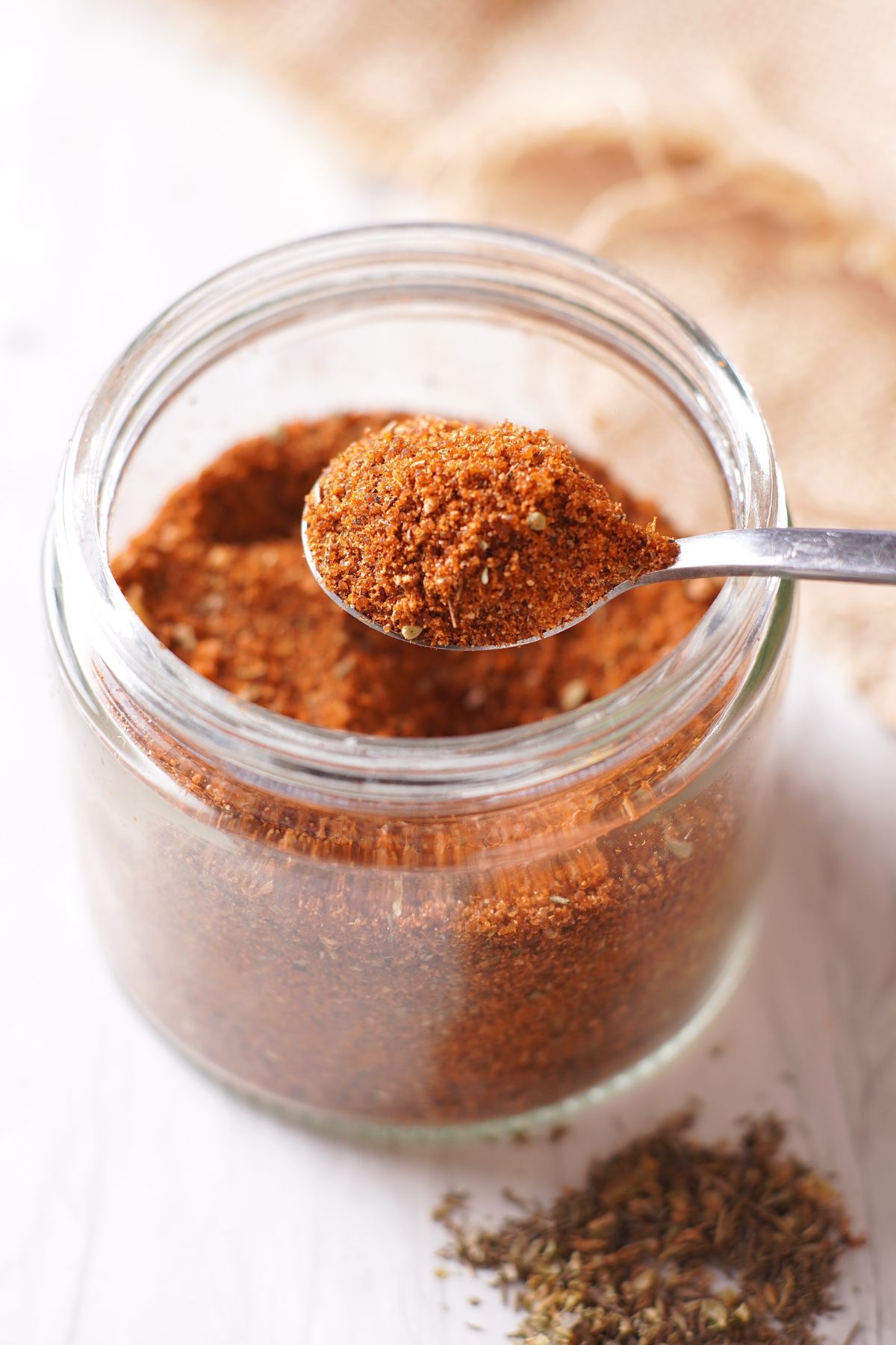 a scoop of BBQ Chicken Rub from a mason jar