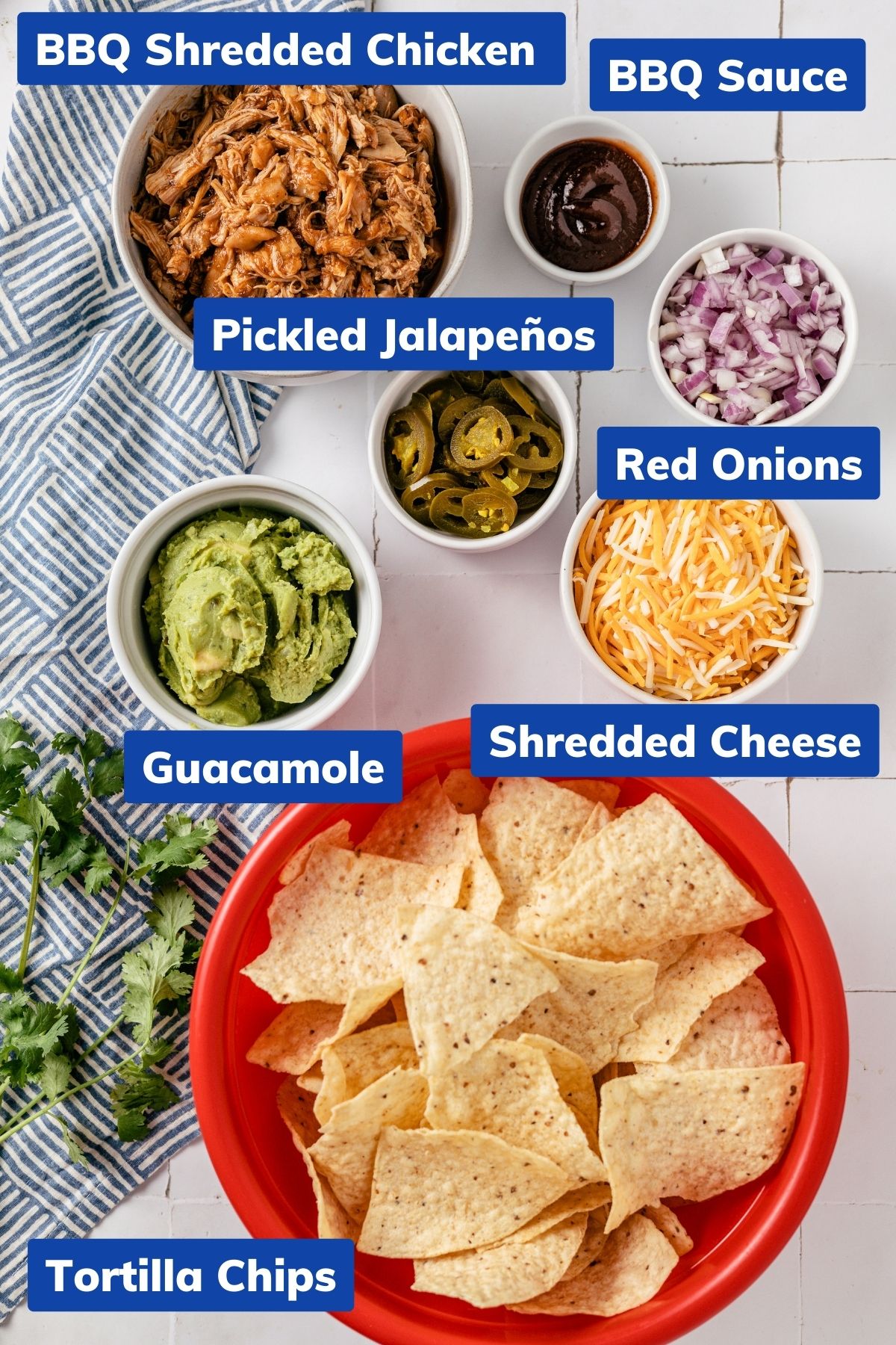 ingredients needed to make bbq chicken nachos like bbq shredded chicken, bbq sauce, pickled jalapenos, red onions, guacamole, shredded cheese and tortilla chips in separate bowls