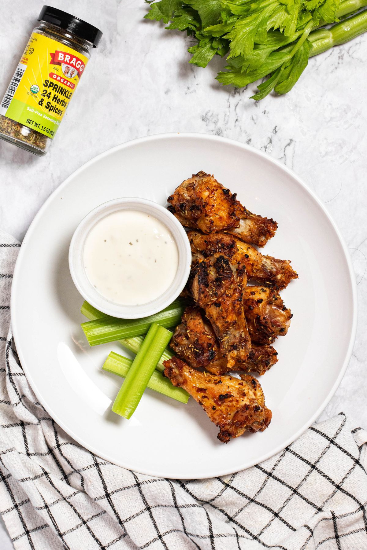 ninja foodi Chicken Wings with a blue cheese dressing and celery stalks on a large plate