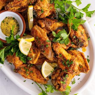 Lemon Pepper Air Fryer Wings topped with slices of lemon and parsley