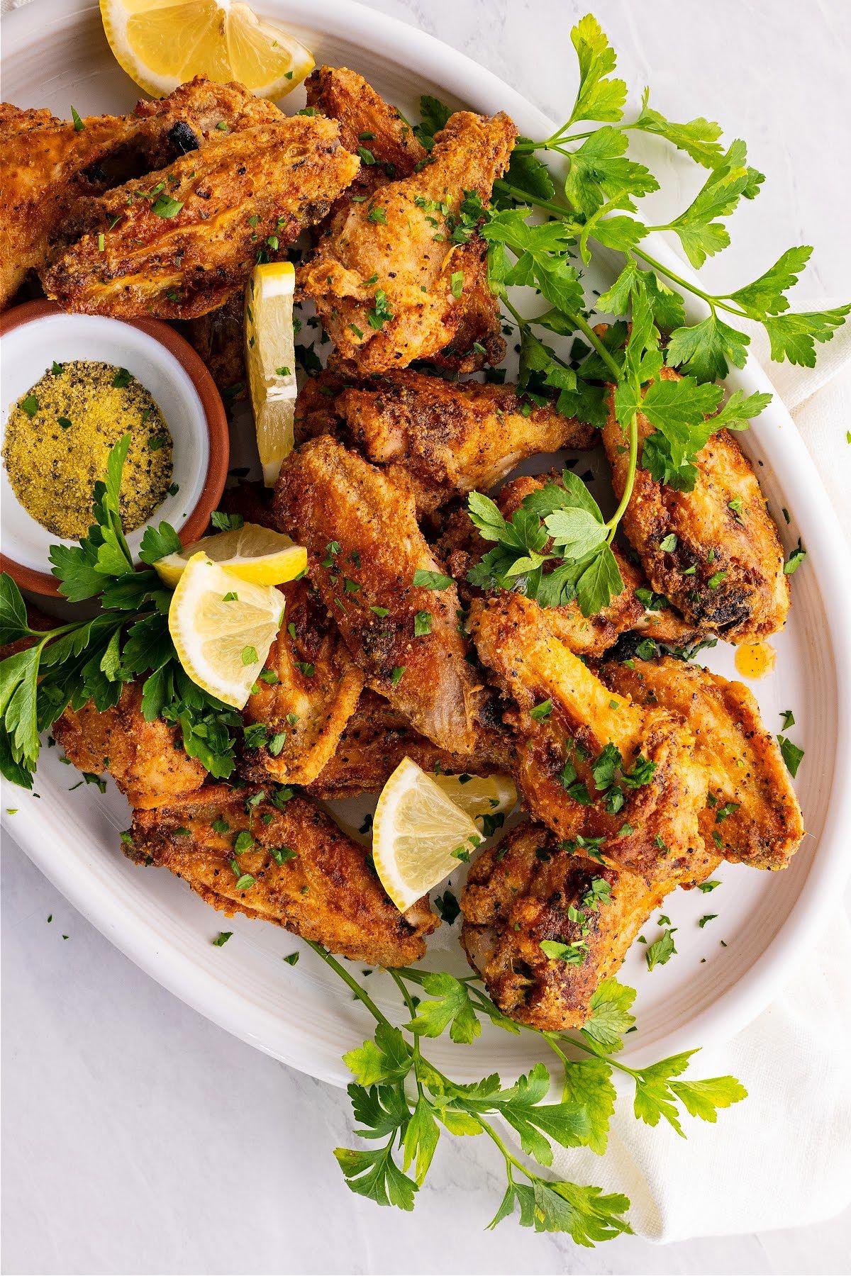 Lemon Pepper Air Fryer Wings topped with slices of lemon and parsley