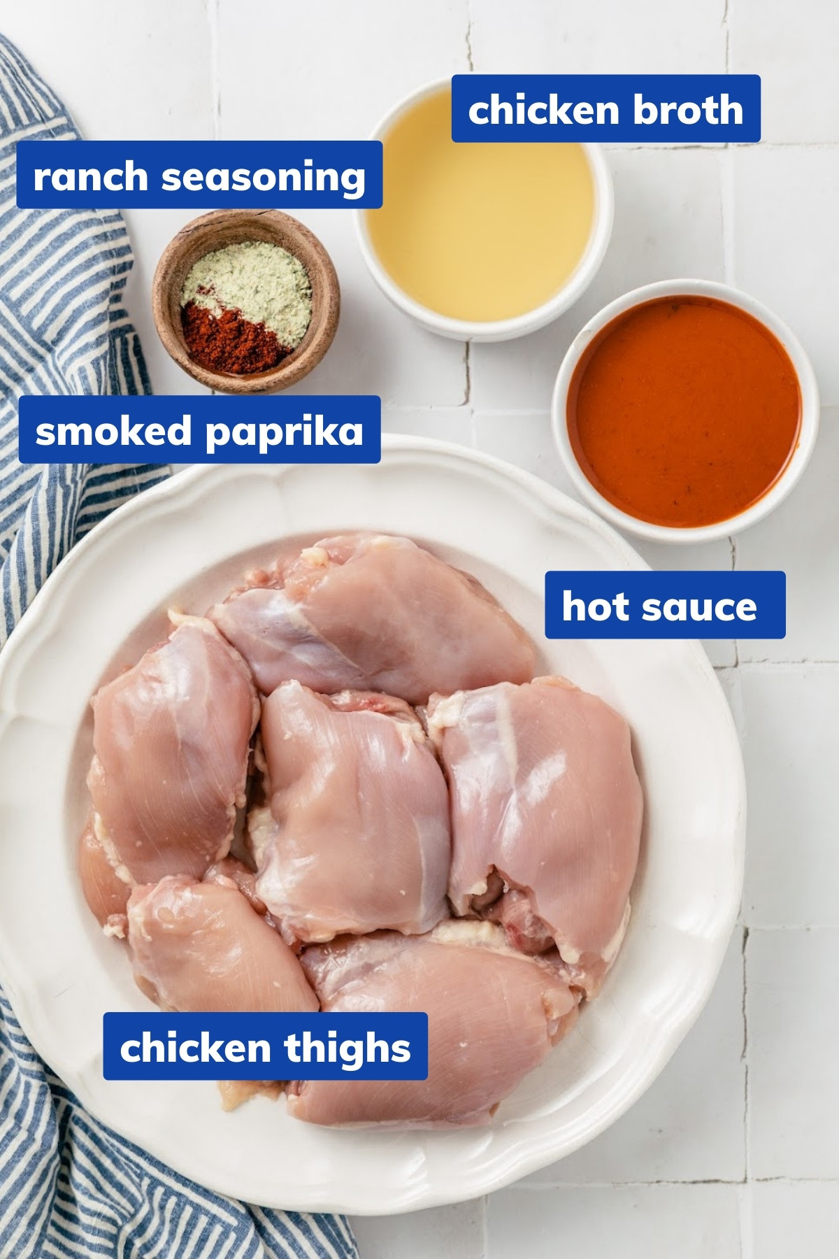 ingredients needed to make buffalo shredded chicken in an instant pot: Chicken thighs, Ranch seasoning, Smoked Paprika, Hot sauce and Chicken broth in separate bowls