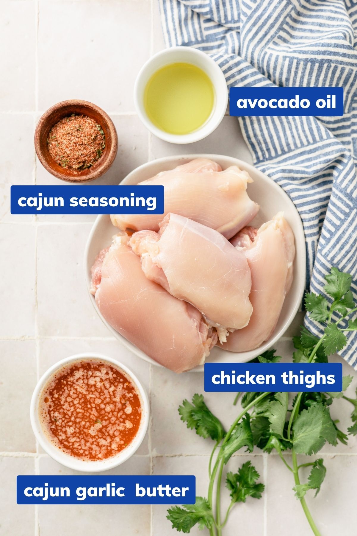 ingredients needed to make cajun chicken thighs: cajun seasoning, avocado oil, chicken thighs and cajun garlic butter on separate bowls