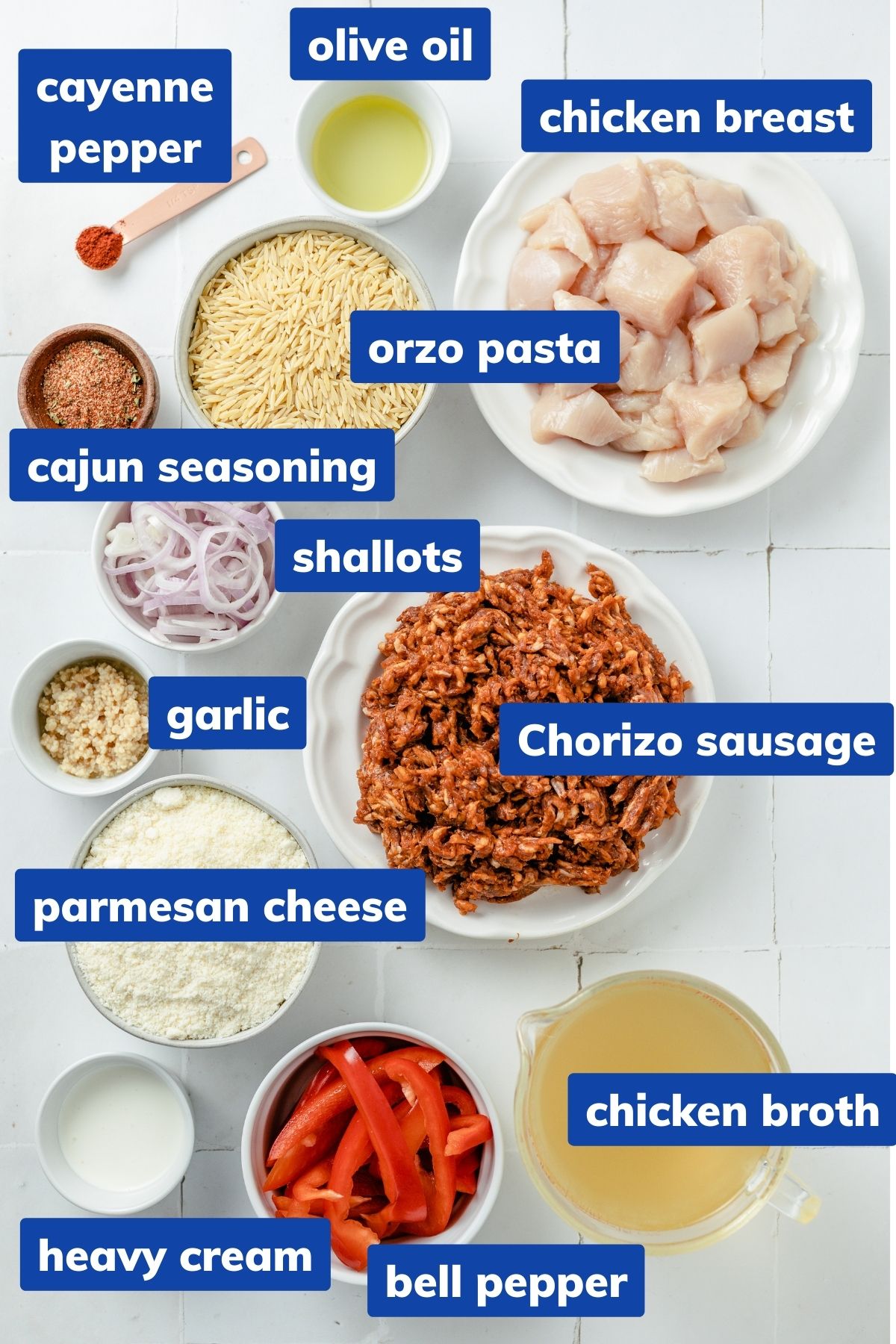 ingredients needed cajun chicken orzo: chicken breast, Cajun seasoning, olive oil, Chorizo sausage, garlic cloves, shallots, red bell pepper, chicken broth, heavy cream, parmesan cheese, cayenne pepper, and dry orzo pasta in separate bowls