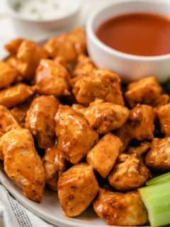 Air Fryer Buffalo Chicken Bites served on a large plate, accompanied by dips and celery sticks on the side