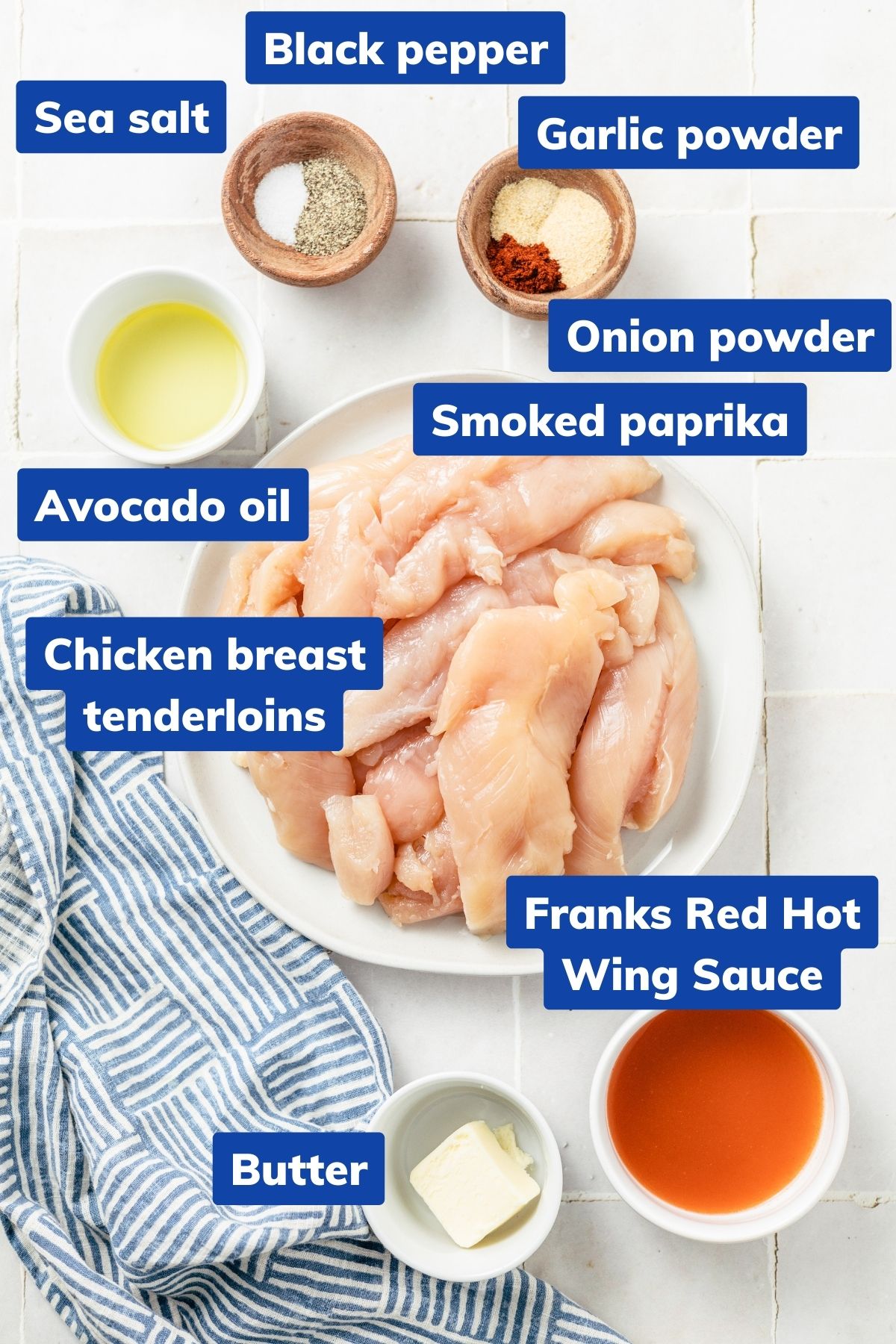 ingredients needed to make buffalo chicken breast tenders: Chicken Breast Tenderloins, Natural Ancient Sea Salt, Black Pepper, Smoked Paprika, Garlic Powder, Onion Powder, Avocado Oil, Franks Red Hot Wing Sauce and Butter on separate bowls