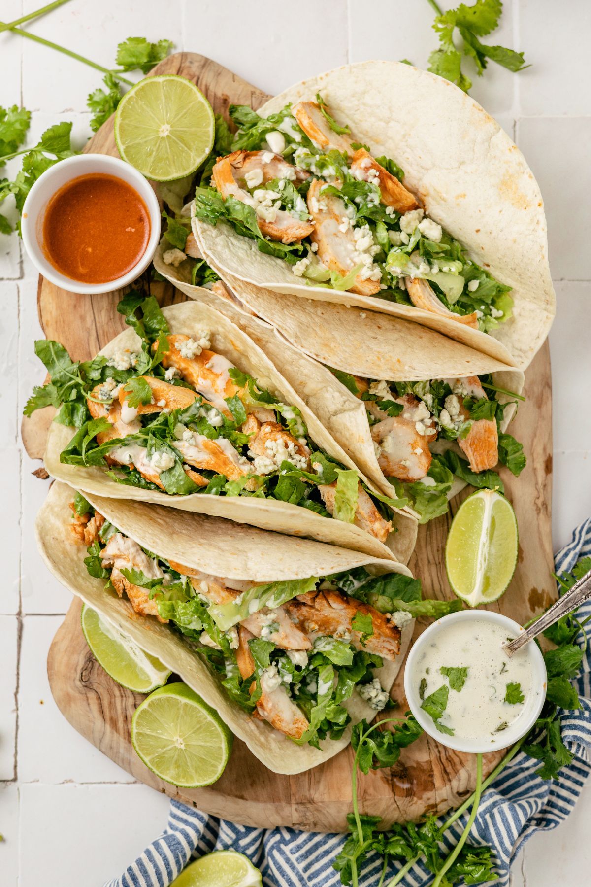 Buffalo Chicken Tacos served with zesty dips and fresh lemon slices on the side.