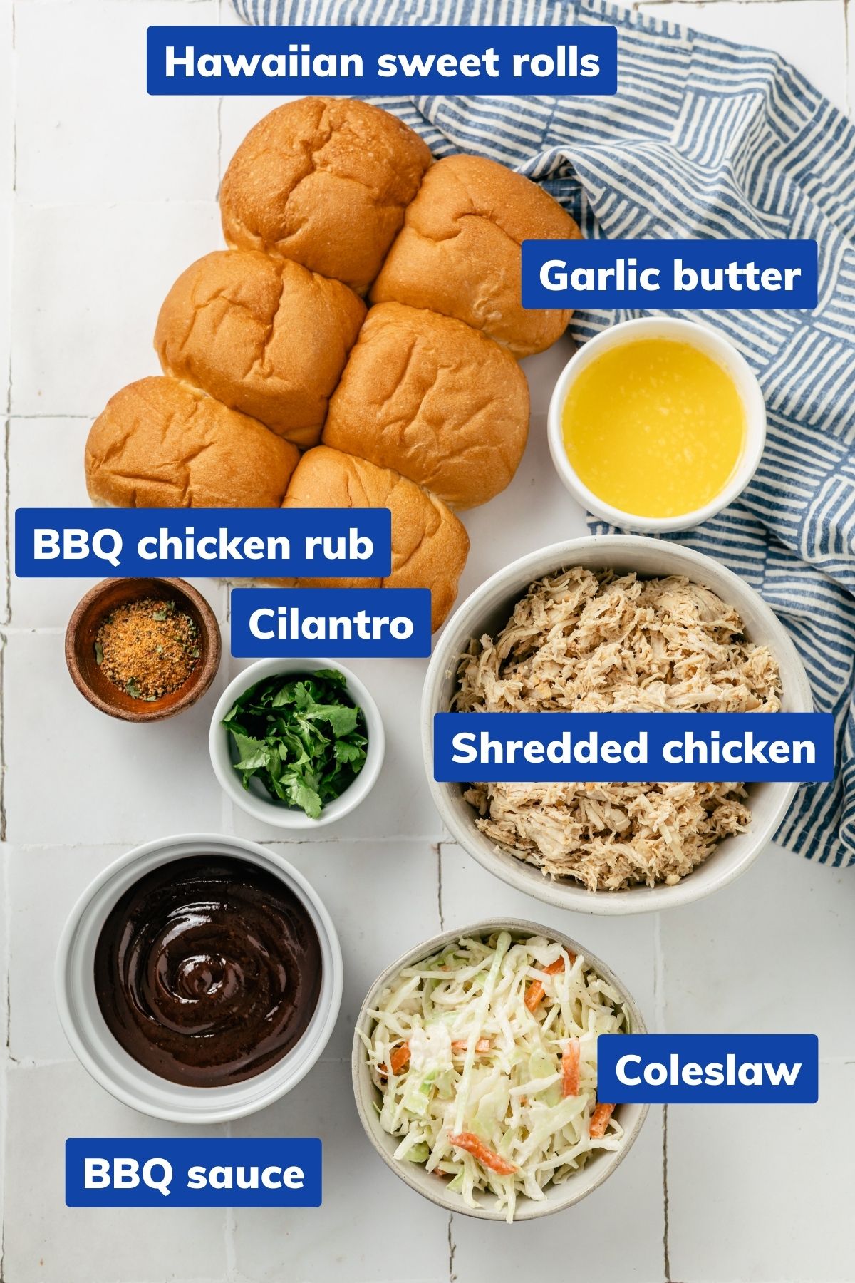 Bowls of ingredients for bbq chicken sliders: Sweet rolls, garlic butter, shredded chicken, BBQ chicken rub, BBQ sauce, coleslaw, and cilantro.