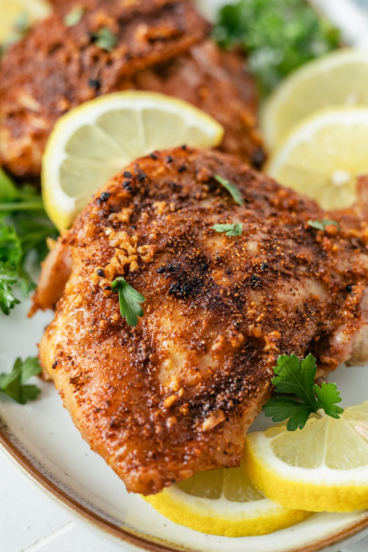juicy and tasty Baked Cajun Chicken on a plate with slices of lemon