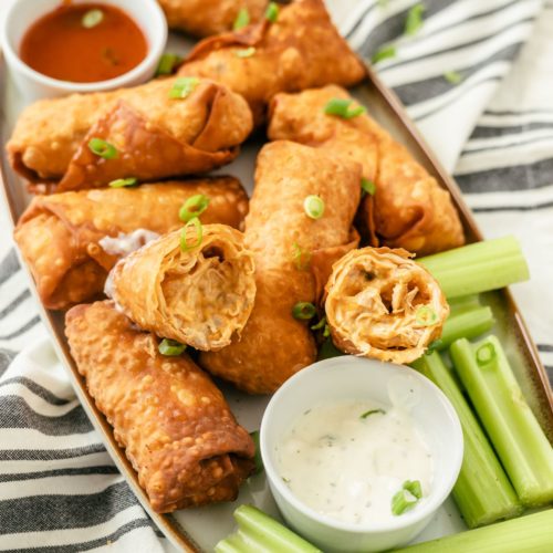 Savory Buffalo Chicken Egg Rolls accompanied by zesty dips and crisp celery sticks for a delicious and satisfying snack