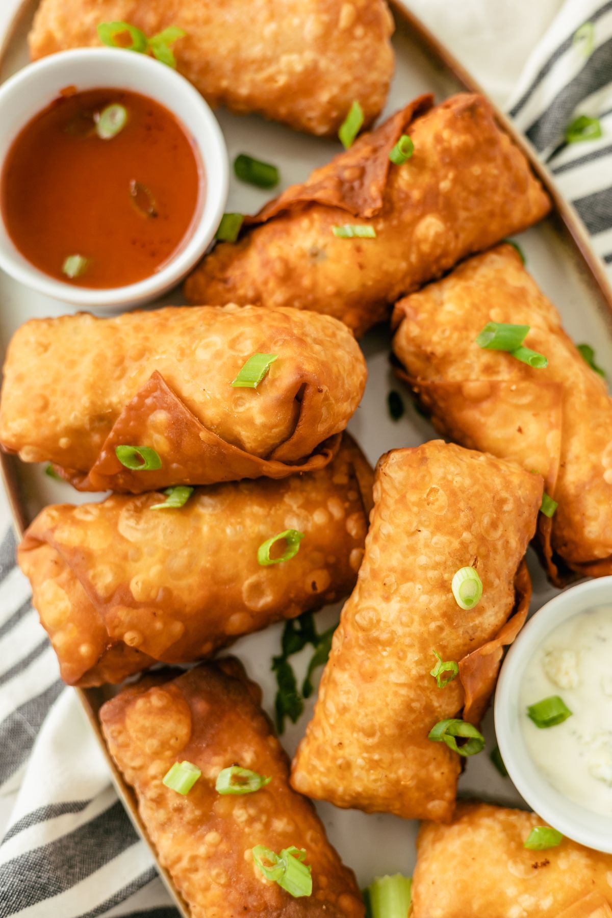 Golden, crispy Buffalo Chicken Egg Rolls served with a tantalizing array of flavorful dips on the side