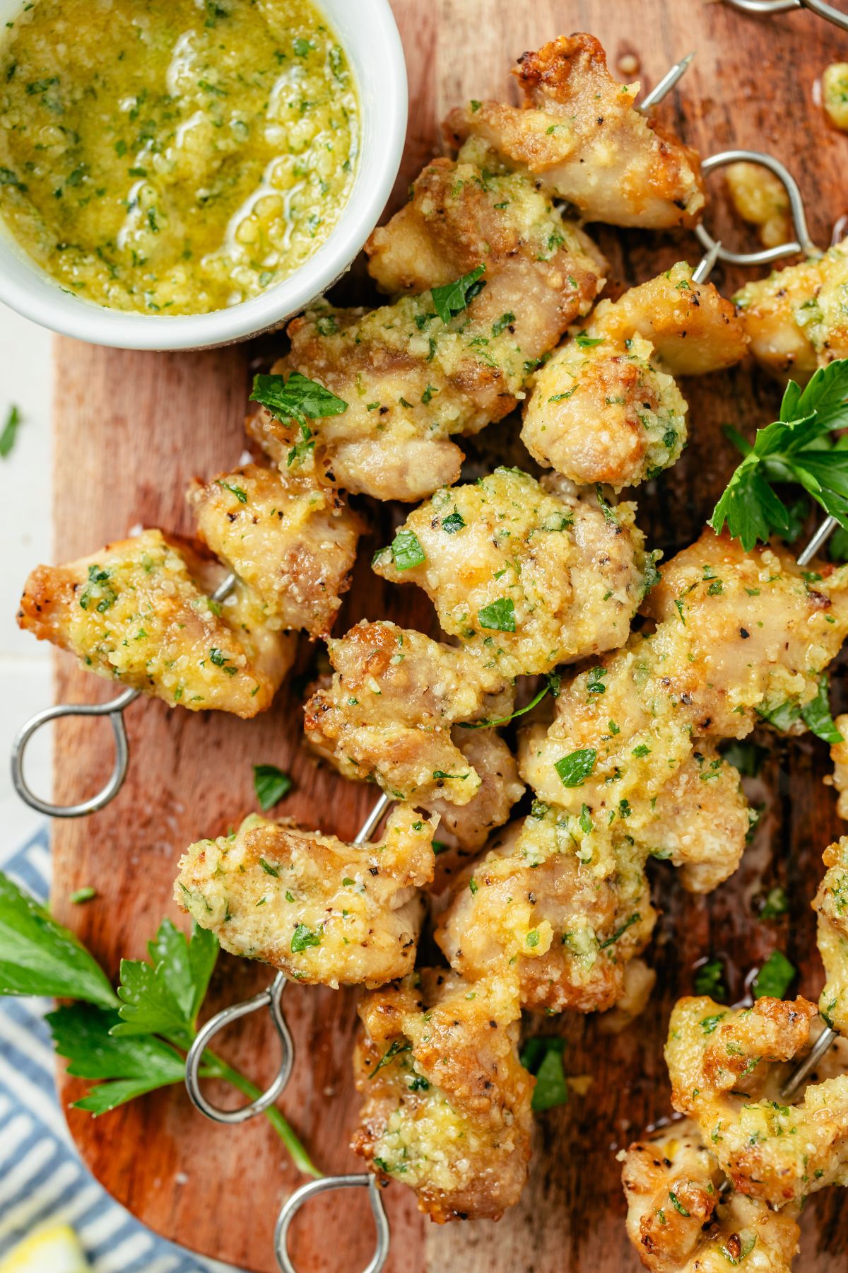 Grilled Garlic Parmesan Chicken Skewers served on a plate with a side bowl of creamy garlic Parmesan sauce, garnished with fresh herbs