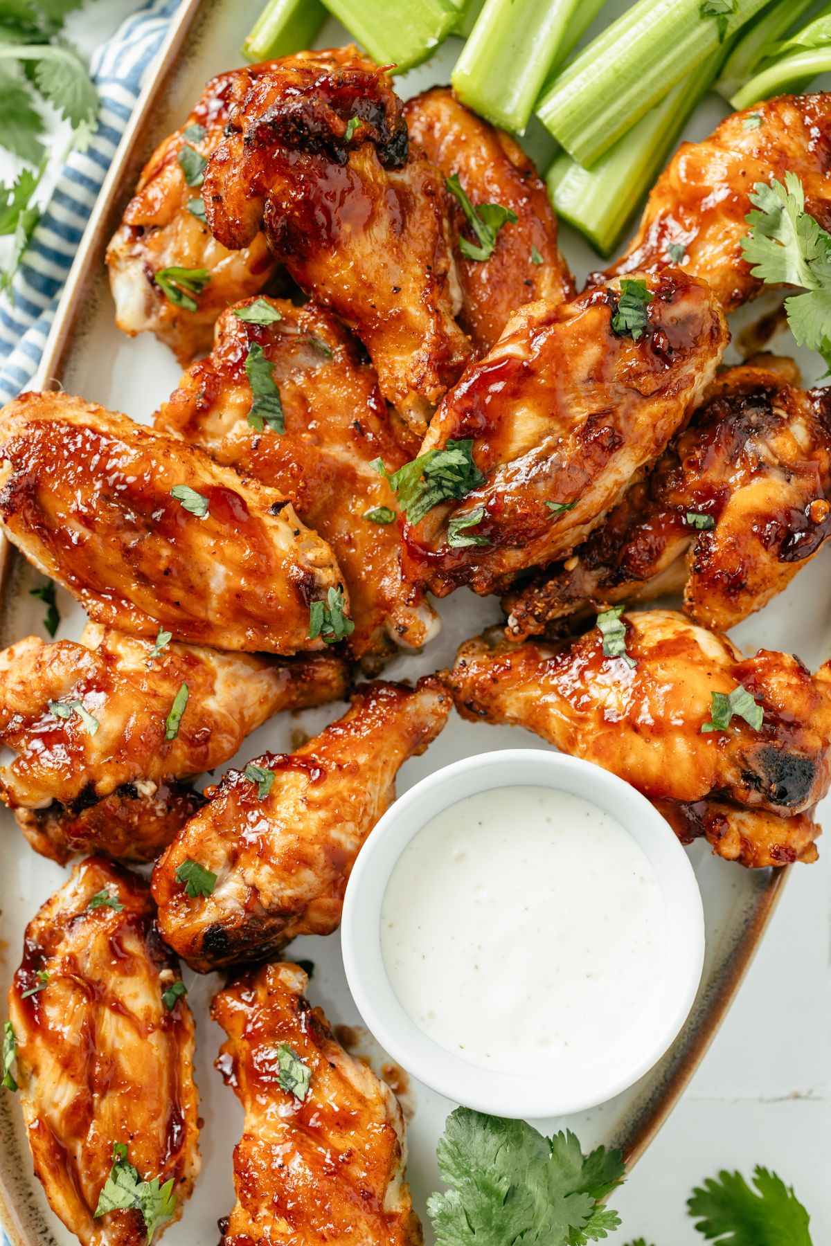 Juicy golden-brown air-fried frozen chicken wings served on a platter with a creamy ranch dip on the side, garnished with fresh herbs for added flavor.