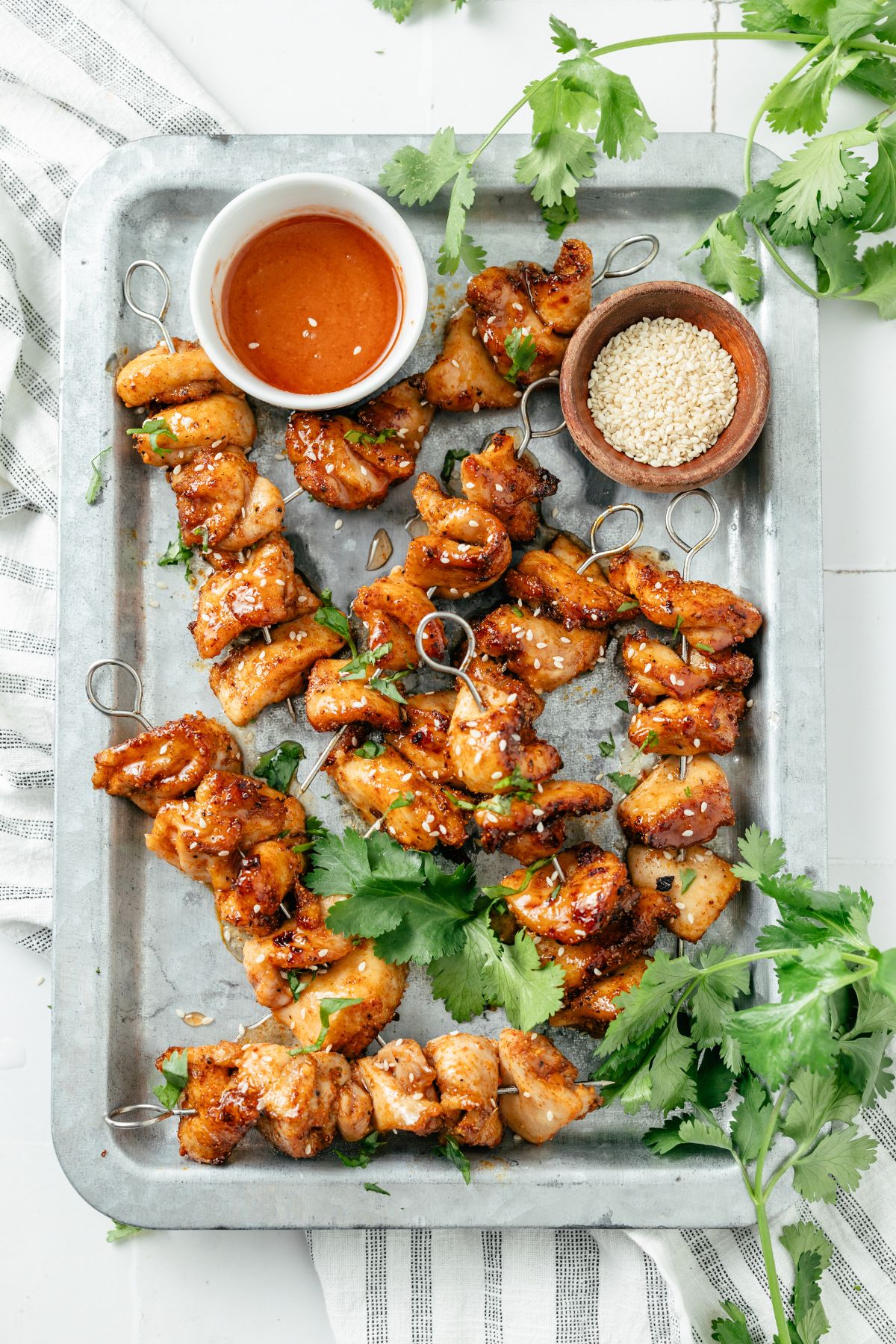 Juicy chicken skewers cooked to perfection in an air fryer, with a golden-brown exterior and BBQ sauce on the side.